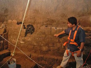 Археолог Серхио Гомес Чавес показывает стену из ровных камней тепетате (вулканического камня) у основания вертикальной шахты. Архивное фото -  INAH / Mauricio Marat
