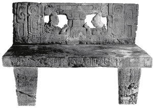 Трон 1 из Пьедрас-Неграс, установленный в 785 году. Спинка, сиденье, а также передние  и боковые стороны ножек трона были украшены иероглифическим текстом. Трон был обнаружен археологами Пенсильванского Университета умышленно разбитым на куски и разбросанным по дворцовой галерее J-6.