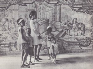 Афро-бразильская семья на прогулке в бразильском городе Салвадор-де-Баия. На стенах, на втором плане, фреска, изображающая сцены завоевания и колонизации Бразилии. Фото – Р. Бурри. Магнум, Париж