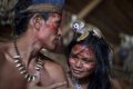 Обезьянка сидит на голове у индианки татуйо недалеко от Манауса, Бразилия, 19 мая 2014 года. Фото - Felipe Dana / AP